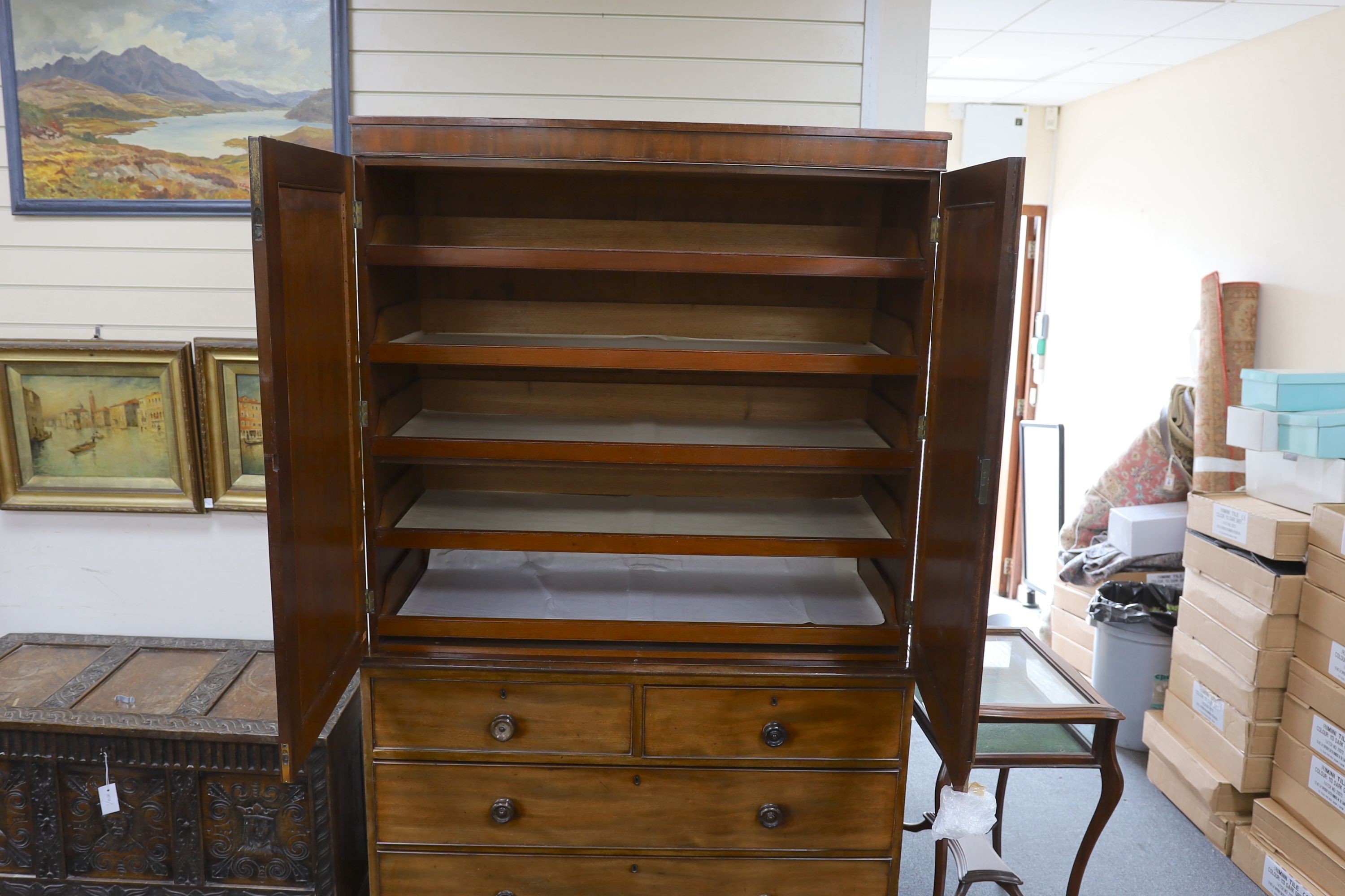 A Regency mahogany linen press, the top retaining sliding trays, length 124cm, depth 56cm, height 200cm